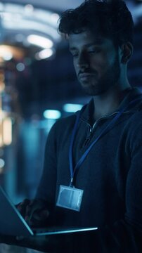 Vertical Screen: Software Developer Standing in a Modern Office, Working on a Laptop Computer. Young Diverse Specialist in Artificial Intelligence is Developing a Quantum Machine Learning Algorithm