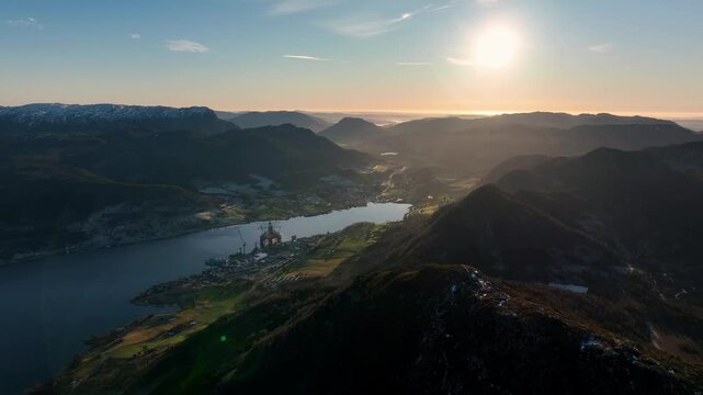 Forward aerial over mountains in Vindafjord and Olen at sunset with fjord and misty valleys below