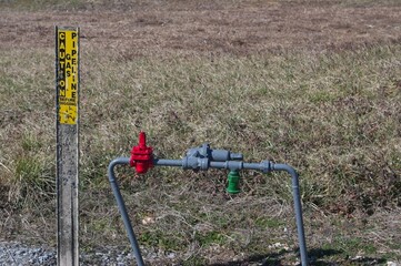 Freshly painted gas line valve and caution post