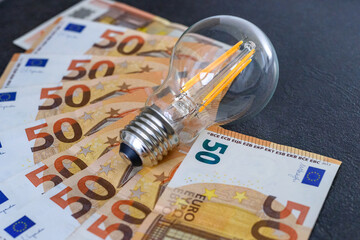 Expensive bills. Light bulb with banknotes indicate inflation and rising electricity bills....