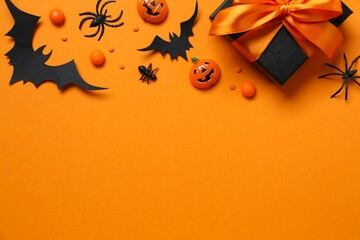 Halloween holiday decorations including gift box, pumpkins, spiders, bats on color background