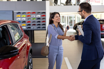 Car dealership, salesman or happy woman shaking hands for vehicle, finance agreement or purchase. Payment, smile or seller in showroom for good service, transportation business or automobile loan