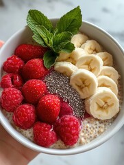 Colorful bowl filled with bananas, raspberries, chia seeds, and