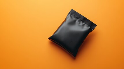 A minimalist pouch bag mockup, crafted from sleek black plastic with a subtle embossed texture, rests against a vibrant orange background, ready to showcase your product is design and appeal.