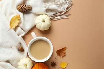 Beautiful autumn composition with cup of coffee, pumpkins and leaves on soft beige scarf