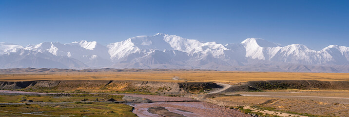 Colorful rural landscape panorama of Alay valley and snowcapped Trans Alay mountain range with...