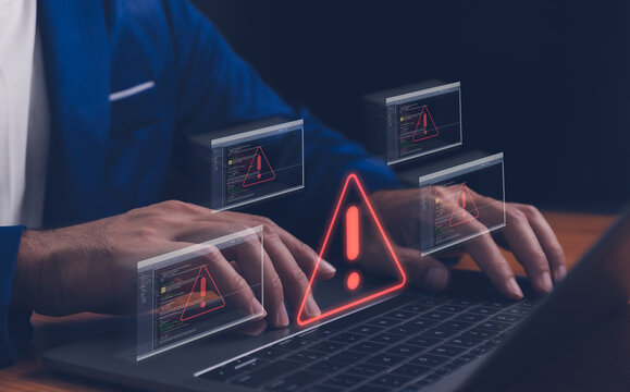 Cyber security concept. data breach man using computer with system hacked alert due to cyberattack on computer network. Triangle caution warning sign alarm for error and maintenance notification.