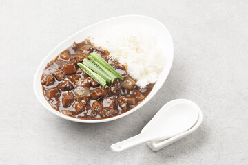 A food made by frying meat, potatoes, pumpkin, and onions in Chinese soybean paste and putting the sauce on top of rice.