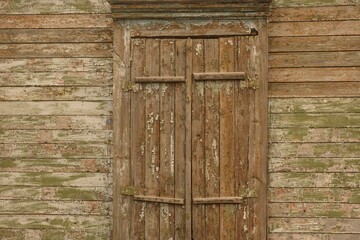 Close-up shot of shuttered window of an old wooden house