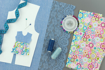 Items for sewing clothes on a gray background. The process of sewing a dress.