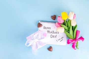 Mother day greeting card, brunch or party invitation background, Spring bouquet of tulip flower, with gift bow and note Happy Mothers day, copy space on colorful light blue background