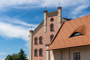 A large building with a red roof against a blue sky