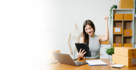 Young businesswoman managing online sales and shipping from a modern home office. Perfect