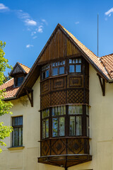 A beautiful white house featuring a wooden roof and an inviting balcony