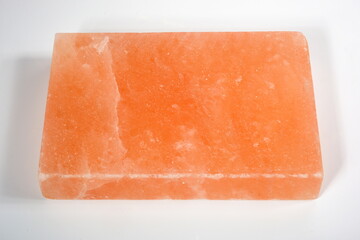 A pinksalt cooking slab  cooking tool made of natural rock salt. Hymalayan pink salt block on white background 