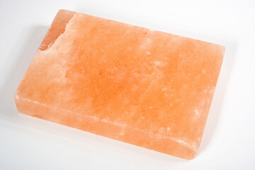 A pinksalt cooking slab  cooking tool made of natural rock salt. Hymalayan pink salt block on white background 