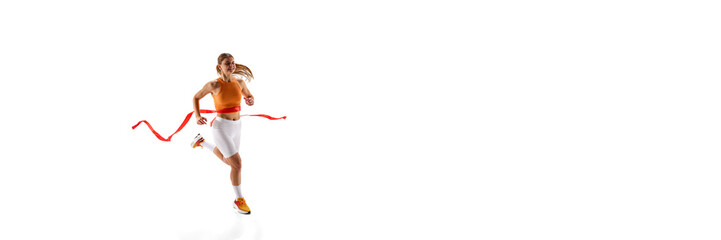 Determined female runner breaking finish line, pushing limits, celebrating victory, expression of joy against white studio background. Concept of sport, competition, achievement, motion. Banner