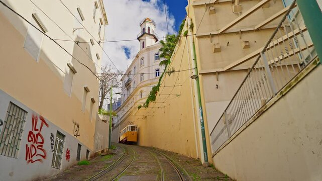 Lisbon, Portugal, 26 February 2025: The old yellow tram, funicular on the narrow street in Lisbon