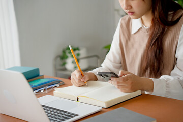 Asian girl student doing exam hand holding pencil writing answer in university classroom education...