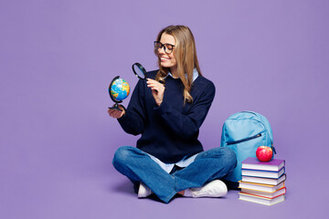 Full body young girl student wear blue casual clothes glasses sit near backpack bag hold Earth...