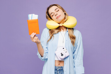 Traveler woman wear blue clothes hold passport ticket neck pillow close eyes isolated on plain purple background. Tourist travel abroad in free spare time rest getaway Air flight trip journey concept