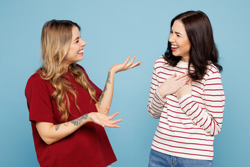 Side view young couple two friends women wearing red casual clothes together talk speak to each...