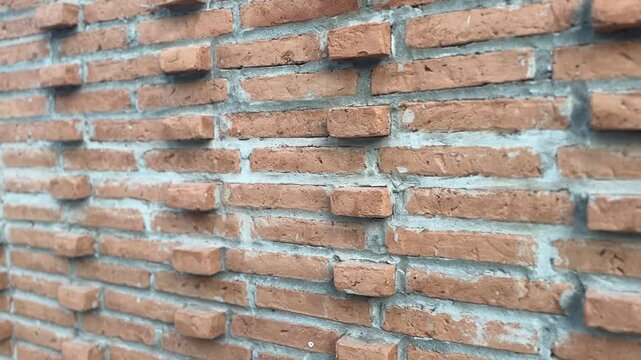 Close-up of brick wall texture with rough surface and earthy red, brown, and gray tones in a traditional layout.
