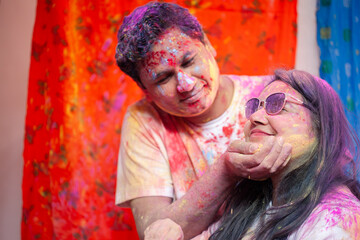 A loving Indian couple joyfully playing with colors during Holi symbolizes love and tradition.