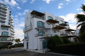 Modern seaside architecture with vibrant clouds and palm trees in a coastal town
