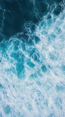 Fototapeta premium Waves crashing against the shore create a stunning display of turquoise and white during a sunny day at the beach