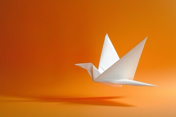 Uccello di origami in volo su uno sfondo arancione, simbolo di libertà e creatività.