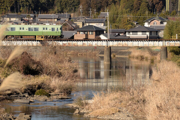 冬枯れの川岸、鉄橋を渡る列車