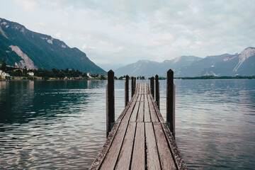 Scenic Wooden Pier on Lake Geneva with Mountain Views in the Early Morning