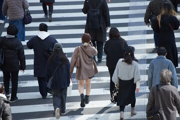 Obraz premium 冬の都市の街の交差点の横断歩道を渡る人々の姿