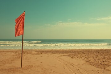 A beach is marked with a red warning flag and a sign indicating that swimming is prohibited due to the dangerous state of the ocean, with waves visible in the background