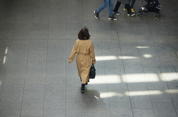 冬の昼の都市の街で歩く一人のビジネスウーマンの姿