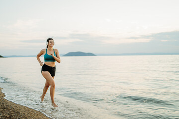 Young caucasian woman run or jog on the beach at sunset	
