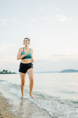 Young caucasian woman run or jog on the beach at sunset	