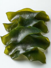 Fototapeta premium Close up of Fresh Green Wakame Seaweed on White Background Capturing its Natural Texture and Vibrant Color for Culinary Applications