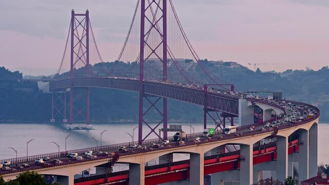 Bridge at sunset from Miradouro do Bairro do Alvito tourist viewpoint with Tagus river, traffic on 25th of April Bridge at sunset. Lisbon, Portugal