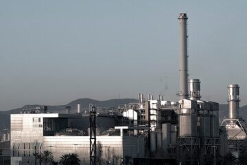 Monochrome industrial landscape with factory buildings and chimneys, portraying urban manufacturing zones.
