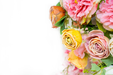 A stunning floral arrangement featuring yellow and pink roses with lush green leaves on a clean white background, ideal for weddings and elegant event decorations