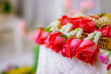 Traditional Thai floral garlands with roses and jasmine in a golden tray, ceremonial decoration for special occasions