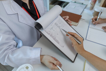 the three doctors are meeting to exchange new knowledge and information they have gained form their medical seminars with each other, a senior doctor is explaining information and knowledge