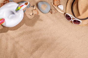 A tropical summer background featuring soft beach sand with delicate palm leaf shadows and sunhat