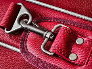 Close-up of a red fabric bag featuring a metal clasp during daylight
