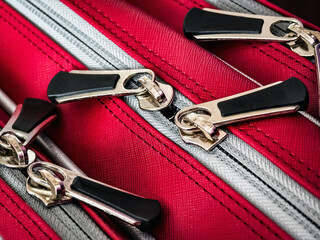 Bright red luggage showcasing detailed zippers ready for travel adventure during summer vacation