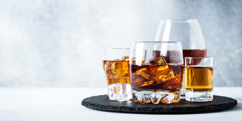 Strong alcohol drink set at light background. Cognac, whisky, tequila and rum.