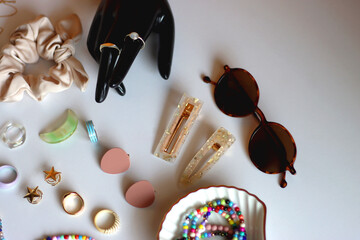 Hand figurine, sunglasses, gold jewelry, colorful bead jewelry, statement rings and various hair...