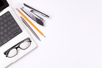 A desk featuring a laptop and office supplies